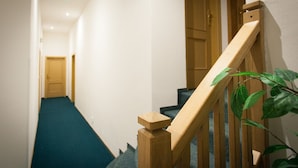 A wooden staircase with a handrail, leading to a door at the top. - Penzion U Vlka (Ceske Budejovice)