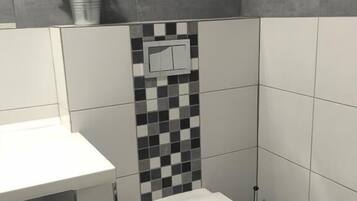 A modern bathroom with a white toilet, a small sink, and a checkered tile backsplash.