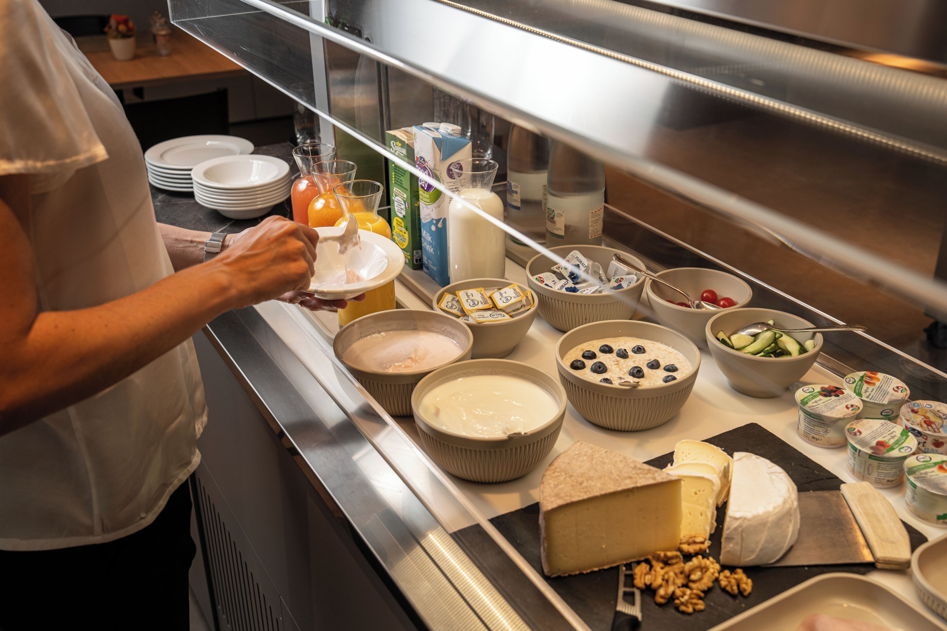 Un bufé con diversas opciones de comida, incluyendo queso, frutas y bebidas.