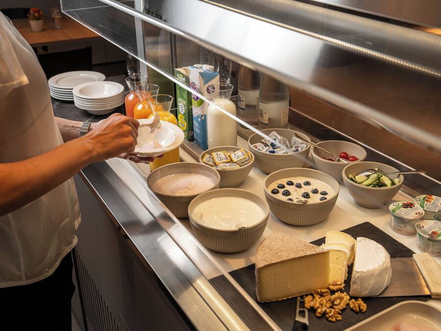 Un bufé con diversas opciones de comida, incluyendo queso, frutas y bebidas.