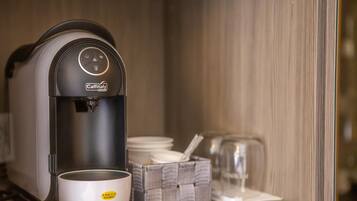 Eine Caffitaly Kaffeemaschine mit einer Tasse und einer Packung Einwegbechern.