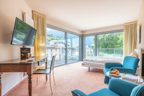Habitación de hotel con una ventana grande, una cama, un escritorio con una computadora y una silla.