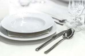 A neatly arranged dining table with a plate, a spoon, and a knife. - OYO Flagship 4584 India Gate (Chennai)