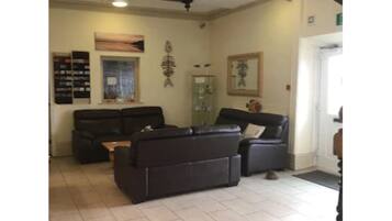 A spacious living area with a black staircase, a fireplace, and a fish-themed wall decoration.
