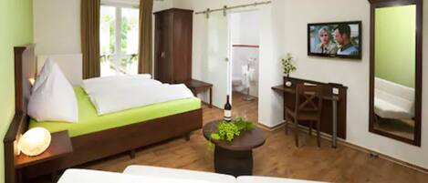 Una habitación de hotel con cama, escritorio, silla, sofá, televisión y ventana.
