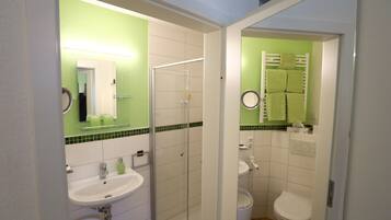 A bathroom with a sink, toilet, and shower.