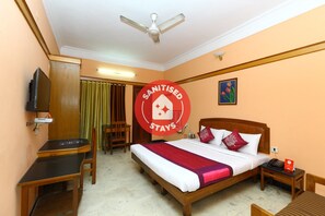 A hotel room with a bed, a desk, a chair, a television, a ceiling fan, and a sign indicating the room is sanitized. - OYO 5208 The Park View Inn (Chennai)