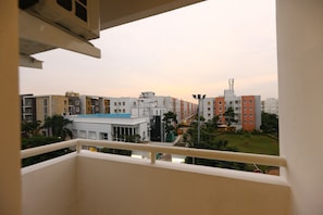 A view from a balcony overlooking a residential area with multi-story buildings, a small park, and a clear sky. - OYO 9260 Olive Castles Inn (Chennai)