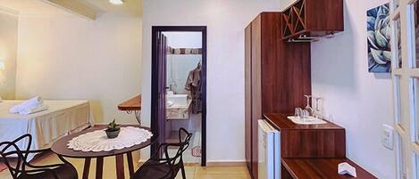 A compact living space with a dining area, kitchenette, and a small bathroom visible through an open door.