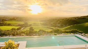 Alberca al aire libre, sombrillas en la alberca y camastros