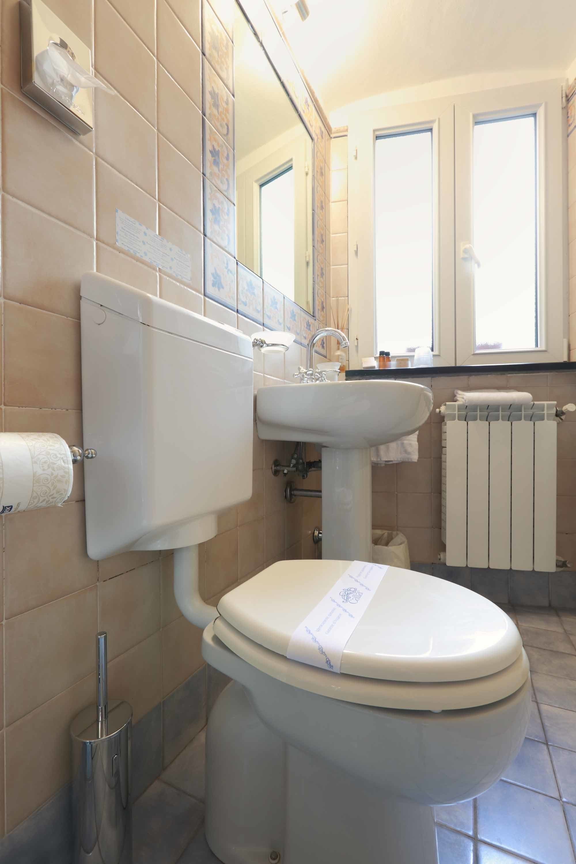 Ein Badezimmer mit Toilette, Waschbecken und Spiegel.