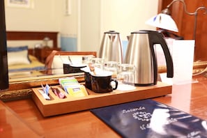 A hotel room with a wooden tray holding a coffee maker, cups, and a menu. - Locanda Il Maestrale (Monterosso al Mare)