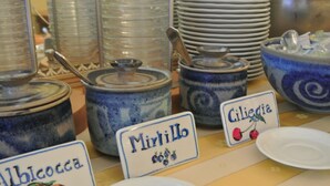 Exhibición de recipientes de cerámica con etiquetas para distintos tipos de conservas.