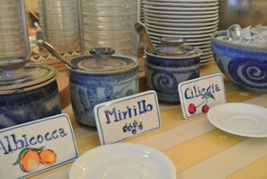 A display of ceramic containers with labels for different types of preserves. - Locanda Il Maestrale (Monterosso al Mare)