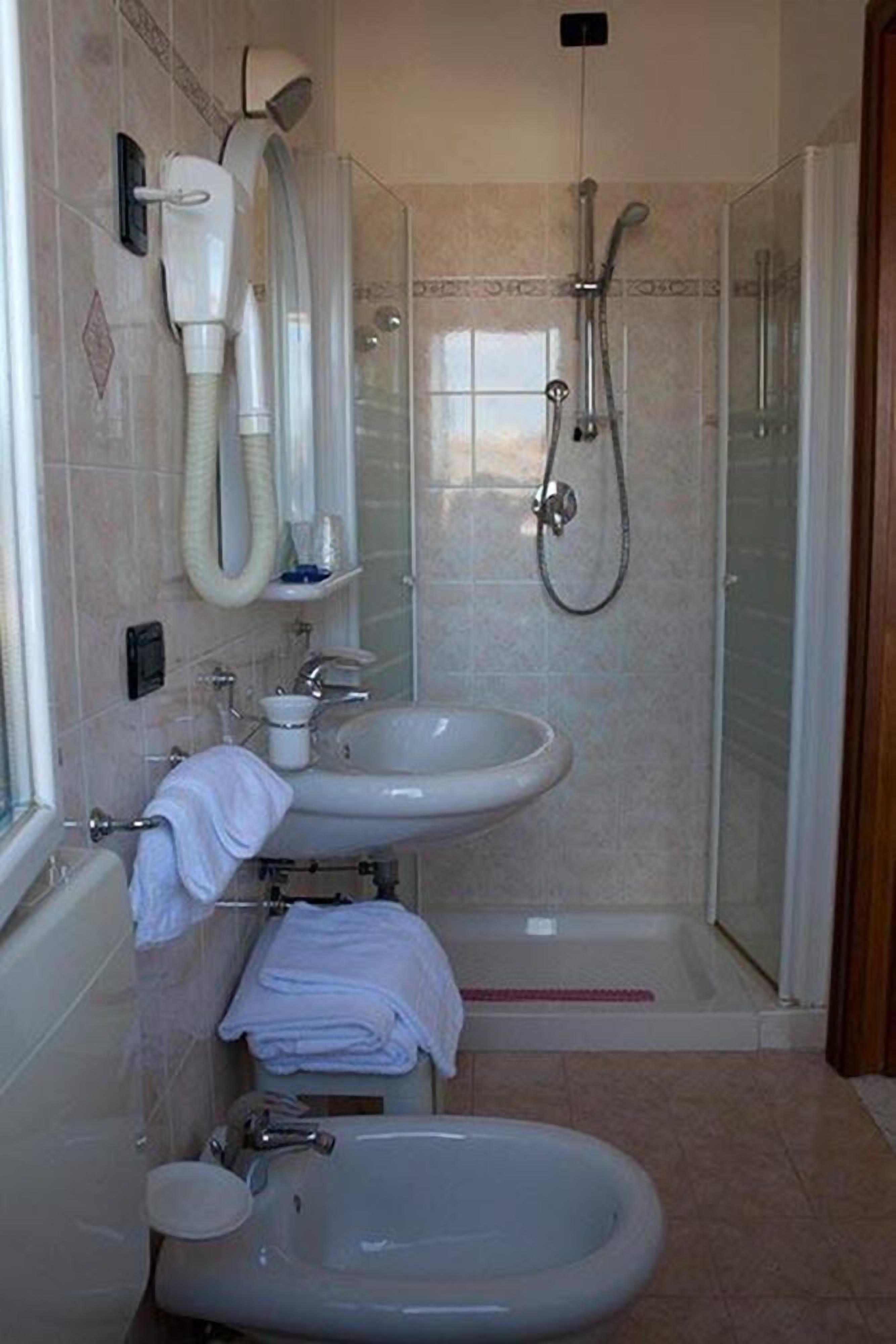 A bathroom with a bathtub, a sink, a shower, and a bidet.