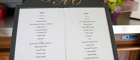 Un panneau affichant le menu, divisé en deux sections intitulées « Menu » en anglais et « Menù » en italien.