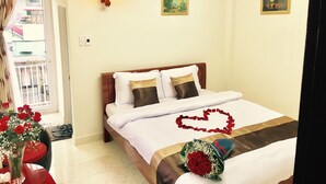 A hotel room with a bed, a nightstand, a vase with flowers, and a view of the outside balcony. - Full Moon Da Lat Hotel (Cam Ly - Da Lat)