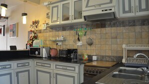 A kitchen with white cabinets, a microwave, a toaster, and a stove. - Residence Mon Choisy (Mont Choisy)