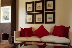 Quarto triplo luxo, acessível, vista para a piscina | Área de estar | TV de tela plana