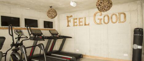 A gym with treadmills, an elliptical, and a punching bag.