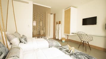 A bedroom with a bed, a desk, a chair, and a television.