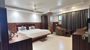 Una habitación de hotel moderna con una cama grande, un escritorio, un sofá y un televisor.