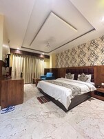 Una habitación de hotel con una cama grande, un cabecero de madera, un escritorio y una silla.