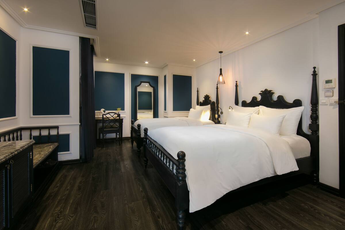 A bedroom with a large bed, a desk, and a chair.
