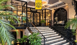 Un hall d’hôtel avec un escalier, un comptoir d’accueil et un panneau indiquant un prix décerné par TripAdvisor.