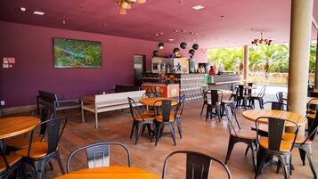 Un restaurante con paredes moradas, una zona de bar y terraza.