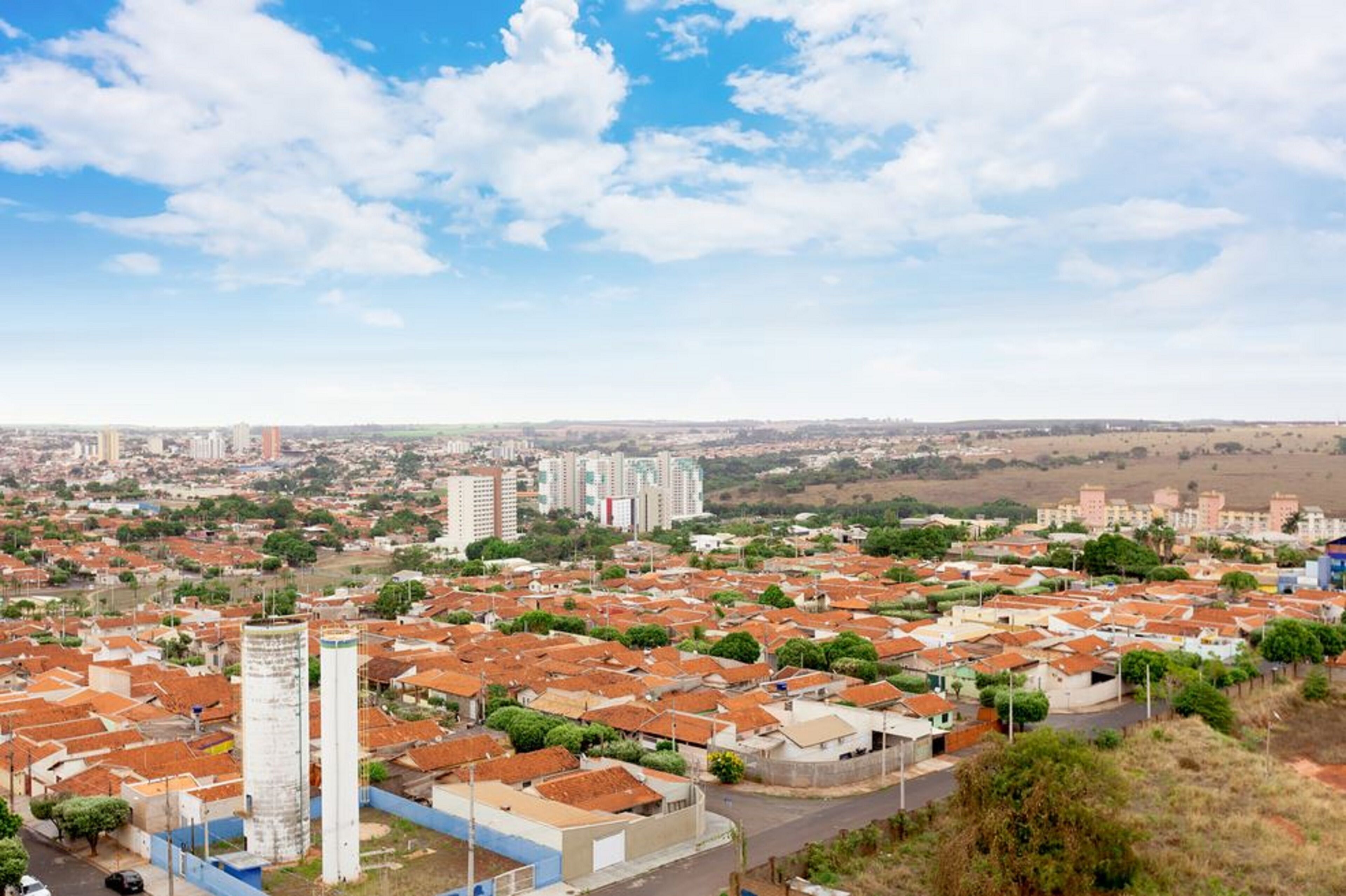 Zona residencial con edificios de diferentes alturas, una torre destacada y un cielo despejado.