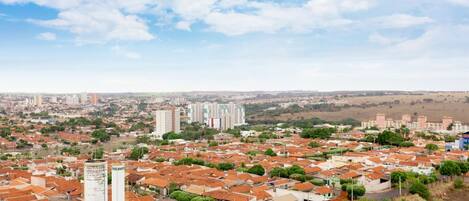 Zona residencial con edificios de diferentes alturas, una torre destacada y un cielo despejado.