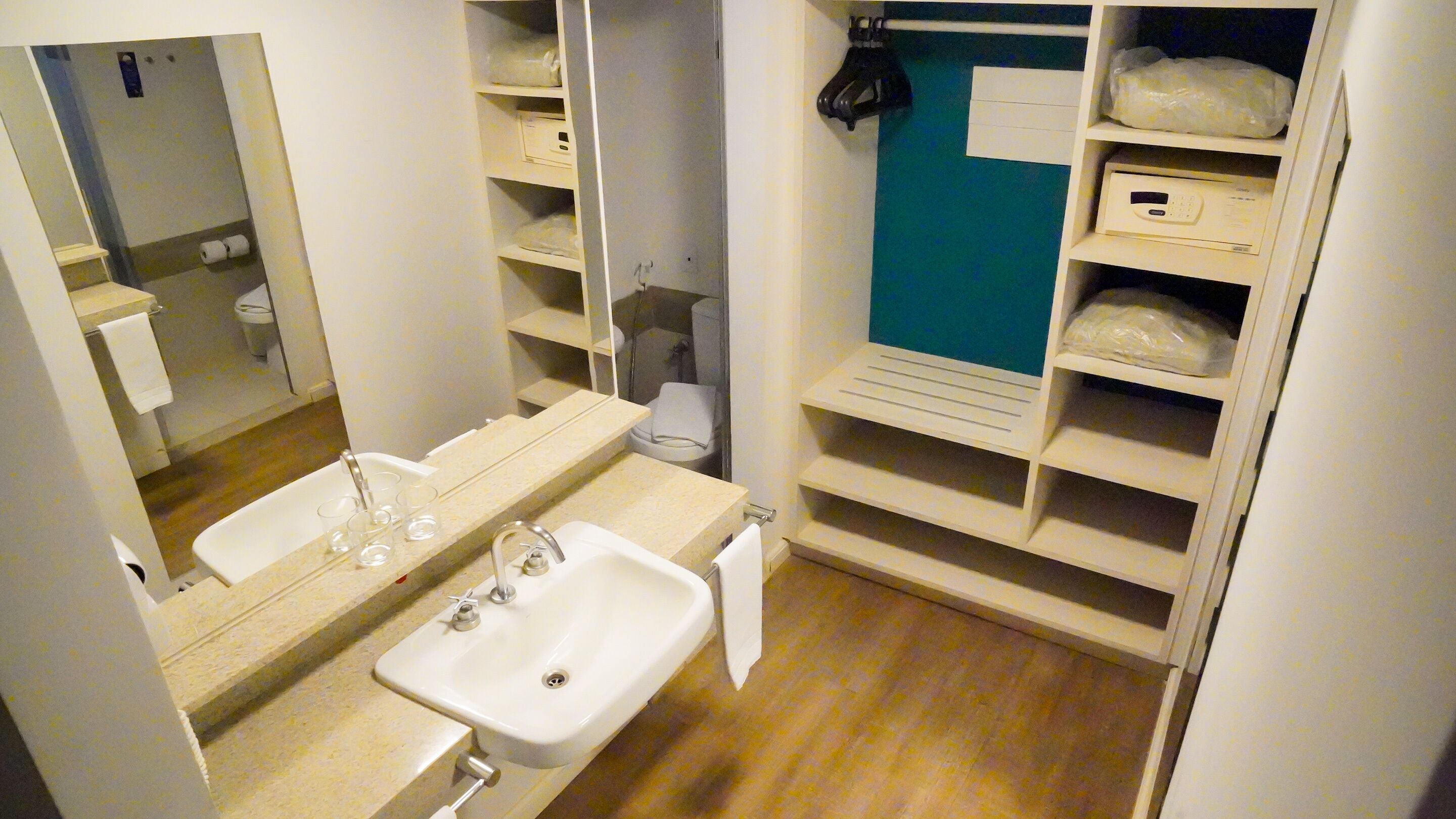 A bathroom with a sink, mirror, and shelves with toiletries.