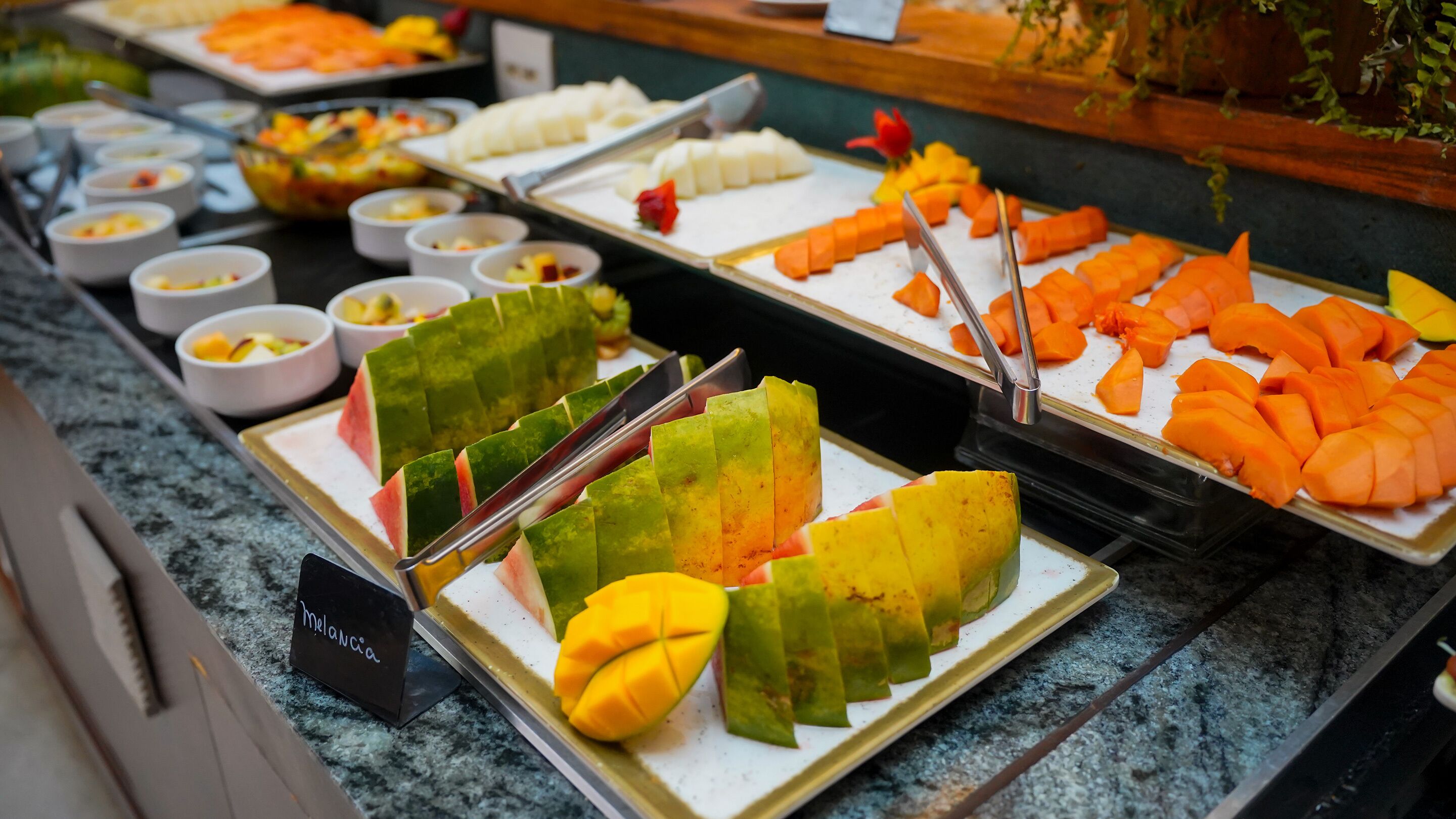 A buffet with various fruits and desserts.