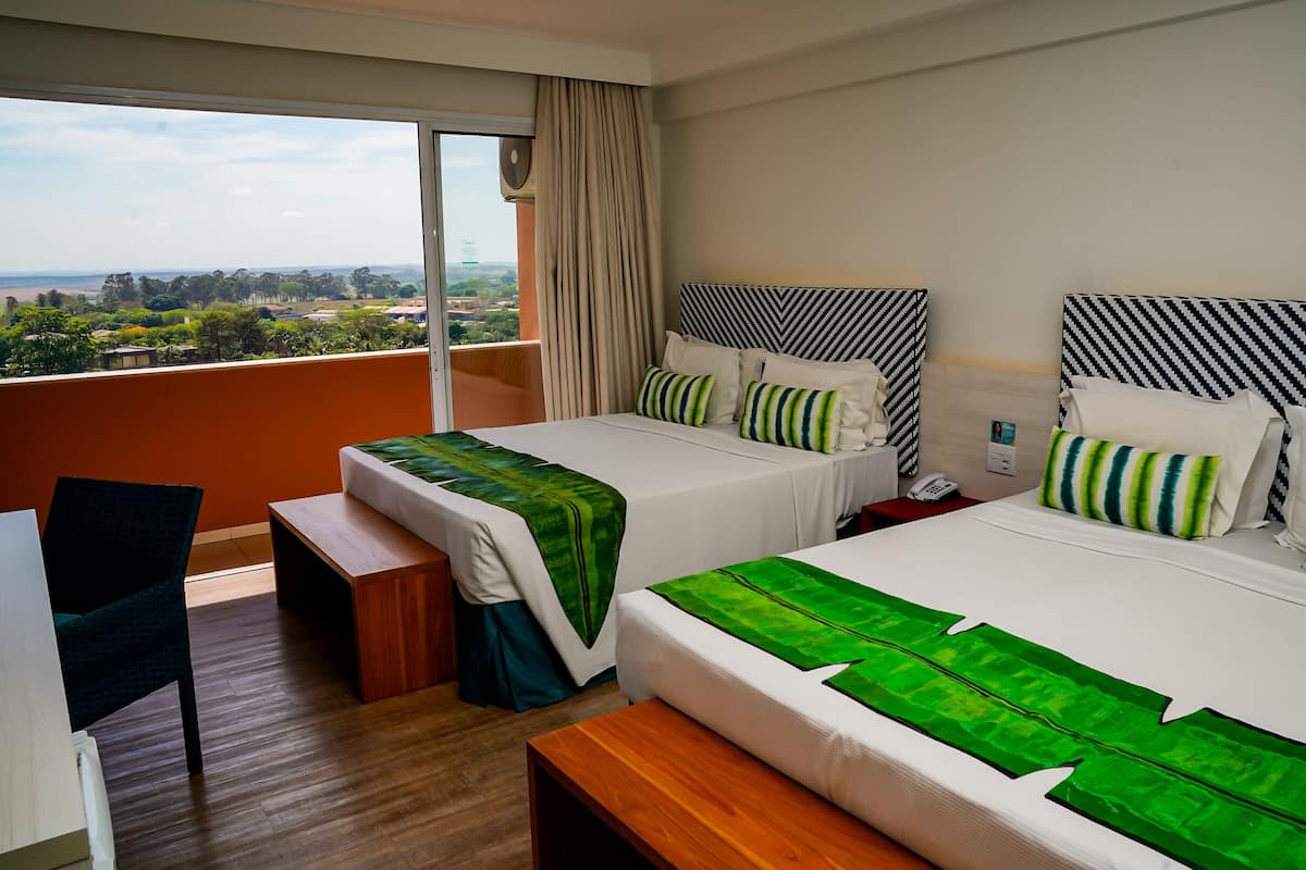 Une chambre d’hôtel avec deux lits, un bureau et une chaise.
