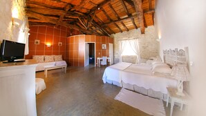A bedroom with a wooden ceiling, a TV, a bed, a desk, and a chair. - Chambres d'hôtes - Les Vents Bleus (Donnazac)