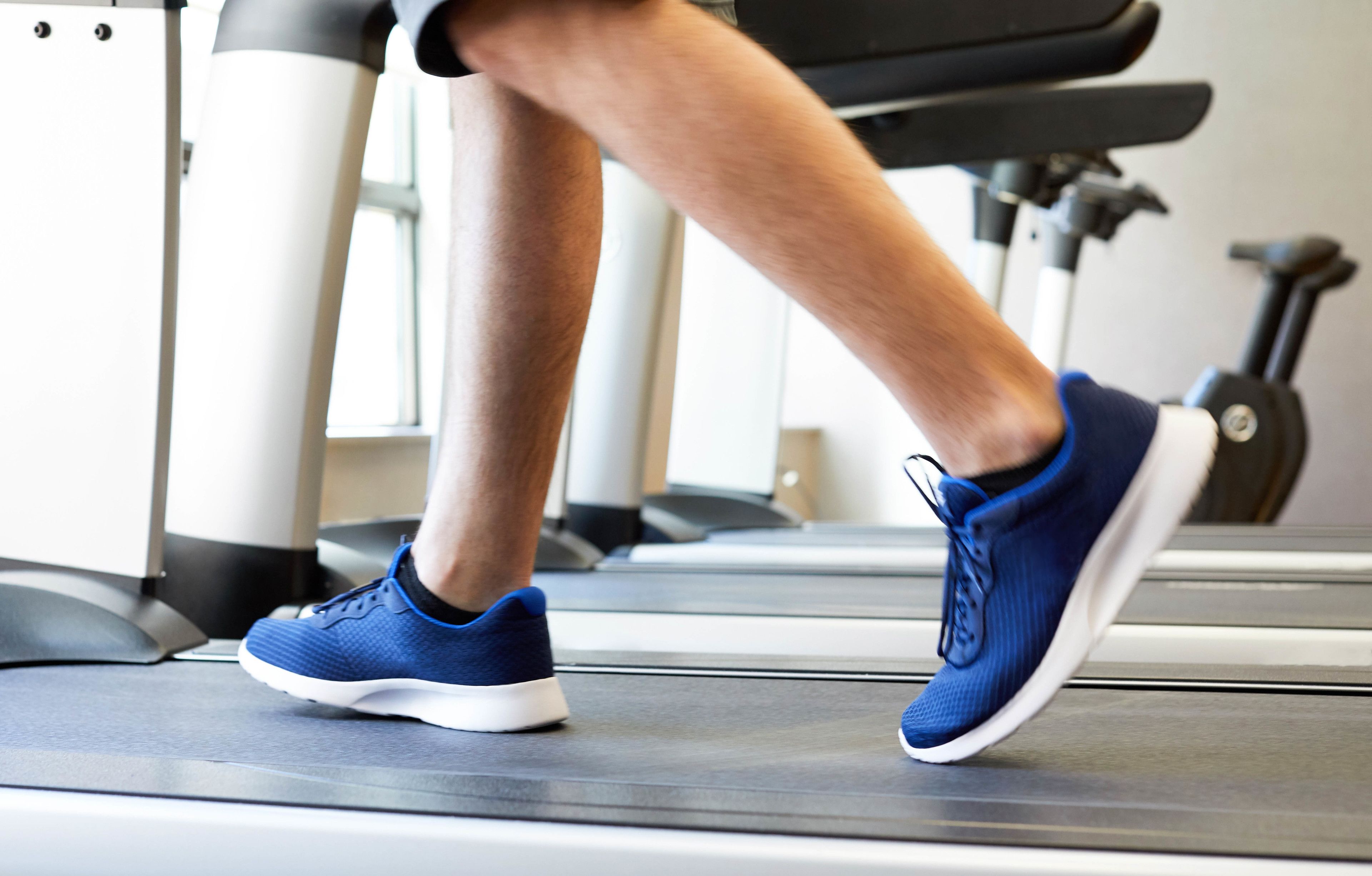 A treadmill in a gym with a person running.