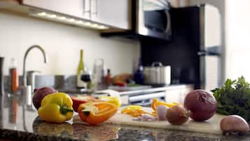 Una encimera de cocina con varios vegetales y una tabla de cortar.