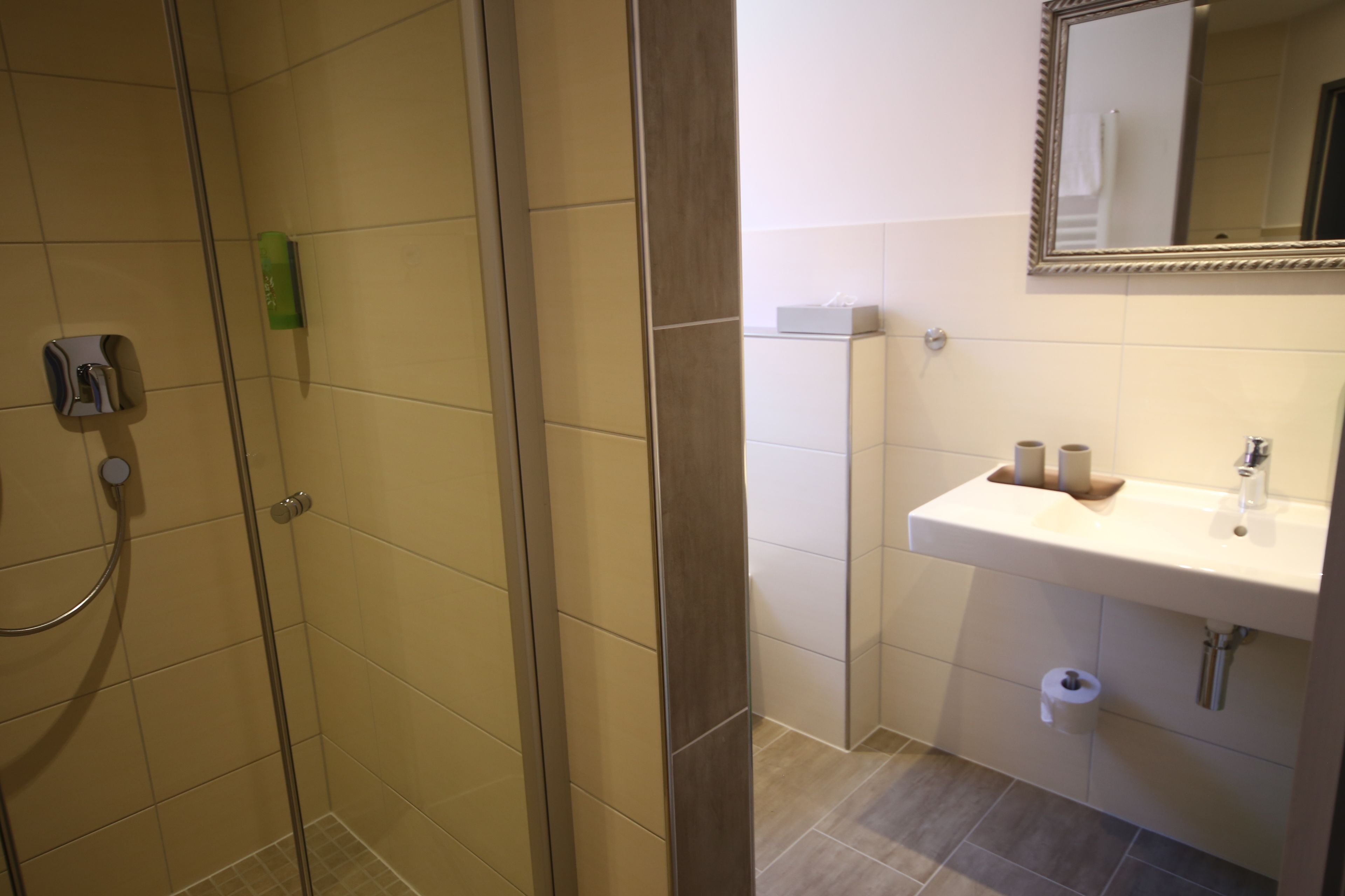 A bathroom with a shower, sink, and toilet.