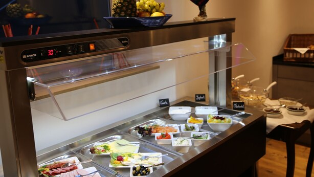 A buffet counter with various food items and a digital clock displaying 30. - Hotel Vintage am Bundesbank Bunker (Cochem)