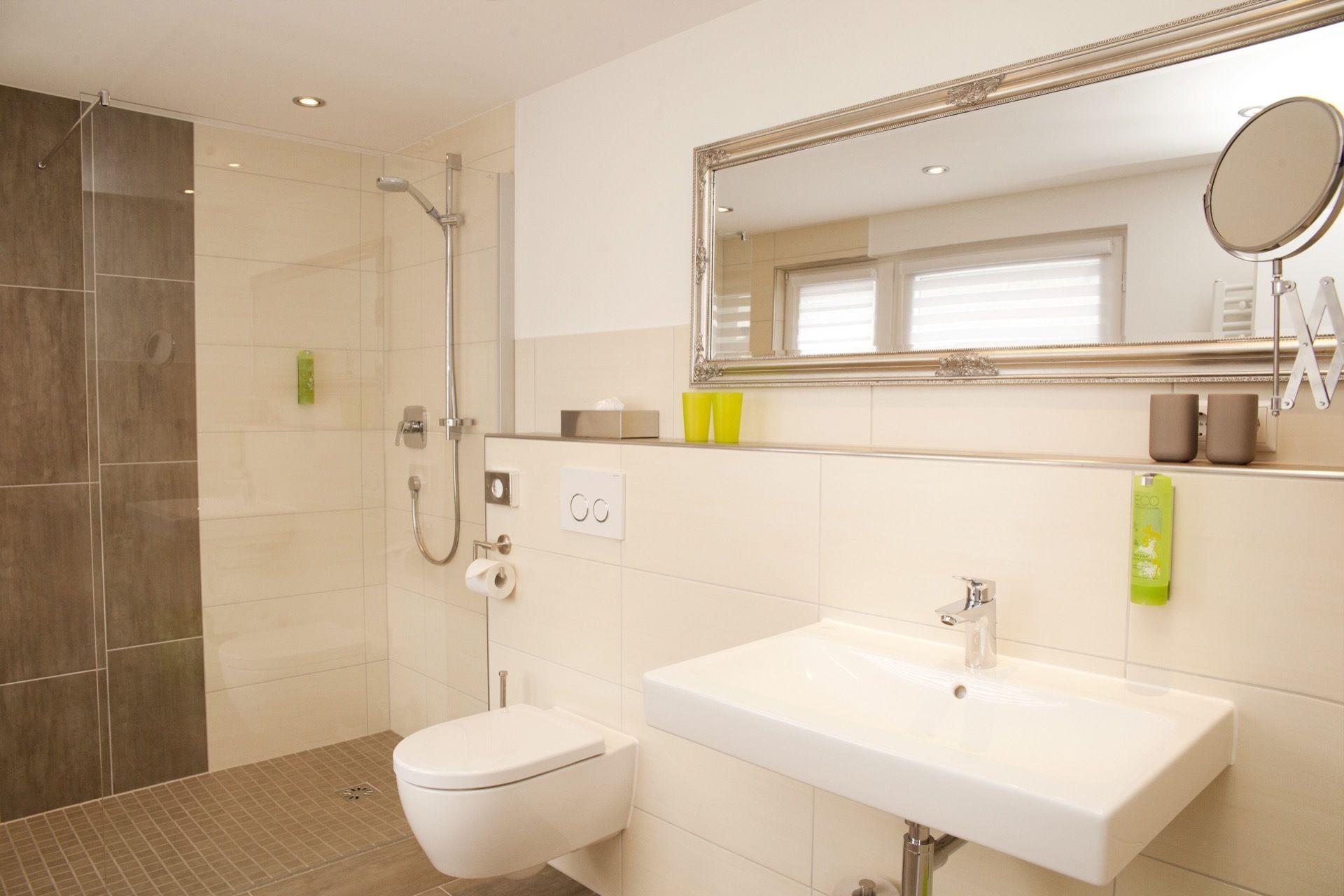 A modern bathroom with a shower, toilet, and sink.