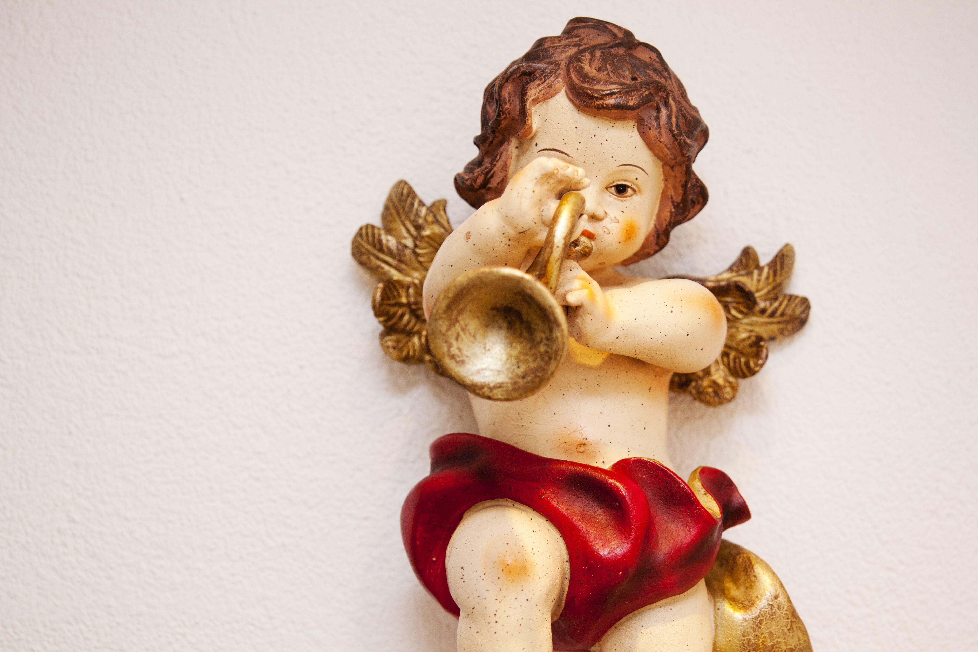 A figurine of a child playing a trumpet.