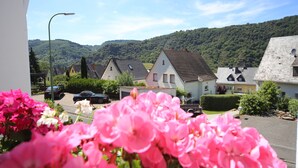 A residential area with houses, a street, and a mountain in the background. - Hotel Vintage am Bundesbank Bunker (Cochem)