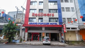 A hotel named RedDoorz with a sign for Grand Populer Hotel. - RedDoorz Plus @ Grand Populer Hotel (Makassar)