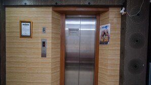 An elevator with a sign indicating 'MAKSIMUM 8 ORANG'. - RedDoorz Plus @ Grand Populer Hotel (Makassar)