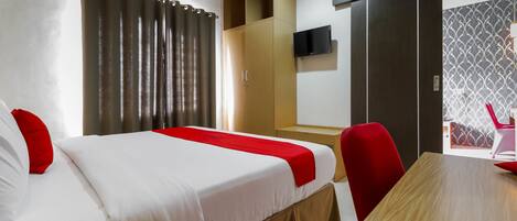 Una habitación de hotel con dos camas, una mesa de madera, un televisor y un armario.