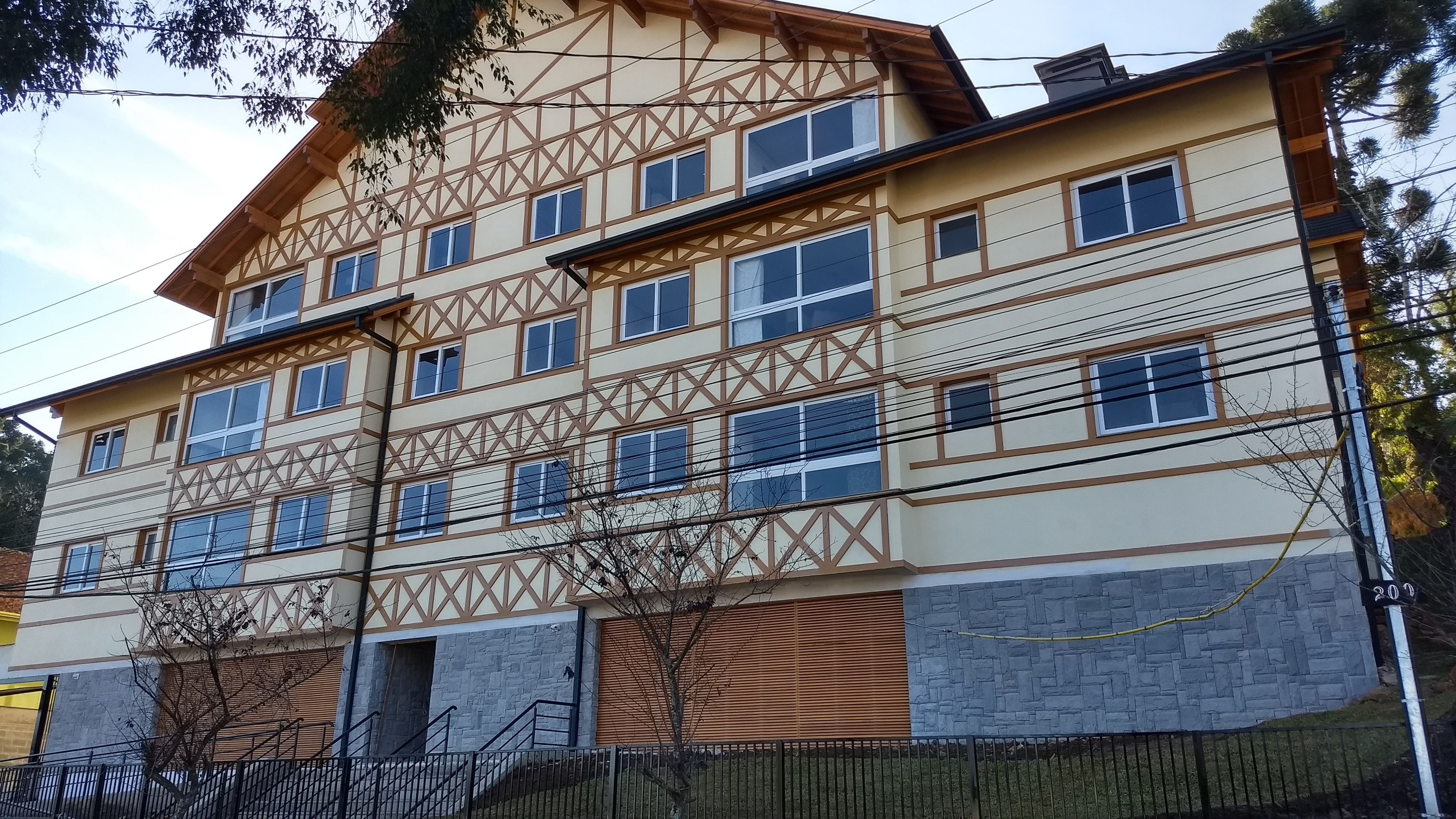 A multi-story building with a traditional architectural style, featuring a mix of wooden and stone facades, multiple windows, and a visible entrance with a staircase.