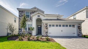 A two-story house with a stone facade, a garage, and a well-maintained lawn. - 1538MVD (Davenport)