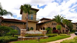 A multi-story building with a stone facade, a balcony, and a sign reading "Bella Piazza". - 431BVD (Davenport)