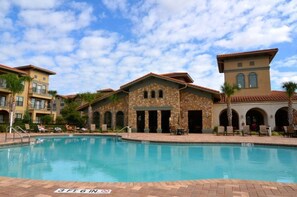 A pool area with a stone building, lounge chairs, and a clear sky. - 431BVD (Davenport)